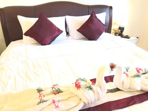 a bed with two swans made out of towels at Naraya Homestay in San Pa Tong