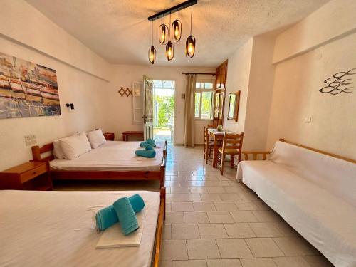 a bedroom with two beds and a dining room at Pansion Episkopi Studios in Skopelos Town