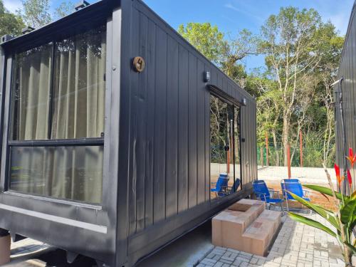 a black tiny house sitting on a patio at Aldeia Mar in Bertioga