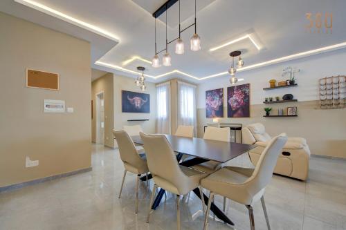a dining room with a table and chairs at Fully equipped 2BR home with Pool & Gym access by 360 Estates in St. Paul's Bay