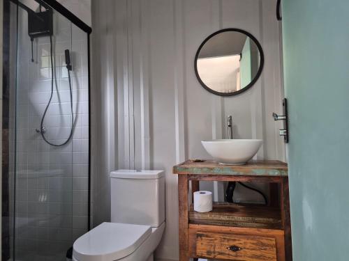 a bathroom with a toilet and a sink and a mirror at Aldeia Mar in Bertioga