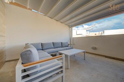 a living room with a couch and a table at Fully equipped 2BR home with Pool & Gym access by 360 Estates in St. Paul's Bay