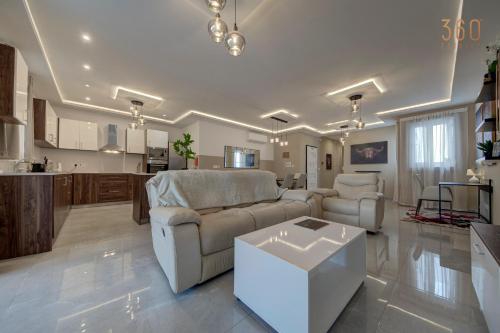 a living room with a couch and a table at Fully equipped 2BR home with Pool & Gym access by 360 Estates in St. Paul's Bay