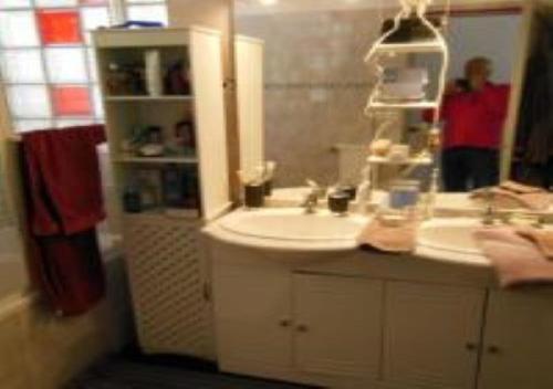 une salle de bain avec un lavabo et un miroir dans l'établissement En ville un coin de campagne, au Cannet