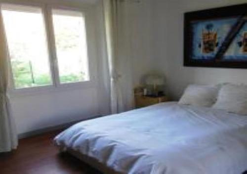 une chambre avec un lit blanc et une fenêtre dans l'établissement En ville un coin de campagne, au Cannet