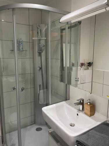 ein weißes Badezimmer mit Waschbecken und Dusche in der Unterkunft Apartment im Herzen von Lübeck in Lübeck