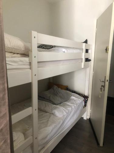 Ce lit superposé blanc se trouve dans un dortoir doté de lits superposés. dans l'établissement Aux Angles superbe studio refait à neuf et très bien équipé, aux Angles