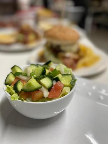 a bowl of salad on a table with a sandwich at Gecko Accommodation in Hotazel