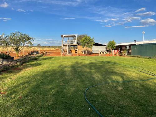 a large yard with a hose on the grass at Gecko Accommodation in Hotazel