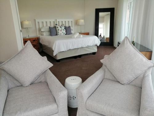 a bedroom with a bed and two couches and a bed at Villa De Mer in Port Alfred