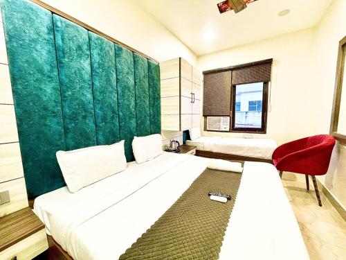 a bedroom with a large bed and a red chair at BLACKWOOD -140 Metres- Near Golden Temple in Amritsar