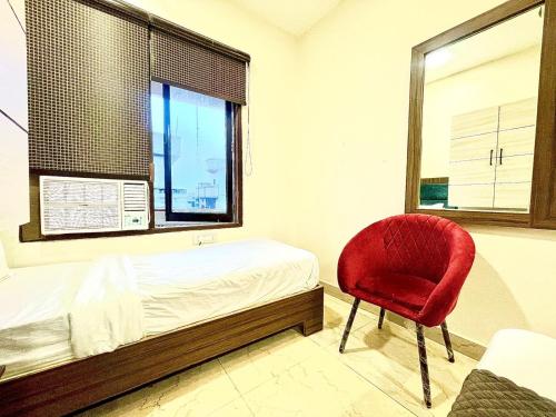 a bedroom with a red chair and a window at BLACKWOOD -140 Metres- Near Golden Temple in Amritsar