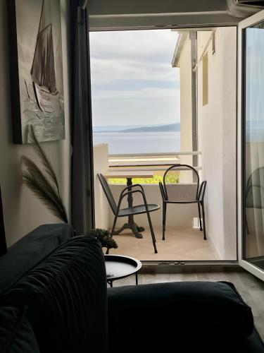 a living room with a couch and a view of the ocean at Accommodation Ventus 2 in Baška Voda