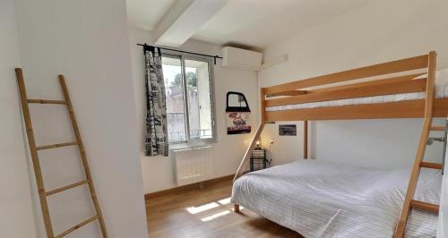 une chambre avec deux lits superposés et une fenêtre dans l'établissement Maison au coeur du village, à Eyragues