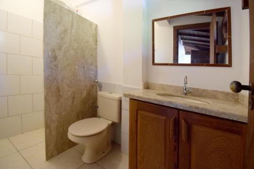 une salle de bain avec toilettes, lavabo et miroir dans l'établissement Casa Exclusiva na Falésia - Barraca da Maré, Arraial d'Ajuda, à Arraial d'Ajuda