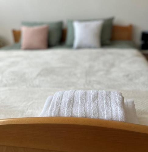 a bed with white sheets and pink pillows at Apartman 'City View' Popovača in Popovača