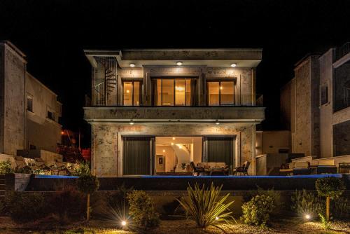 a large house with a balcony at night at Olymp Luxury Villa D - Luxury Escape with Direct Beach Access and Unique Sunsets in Paphos