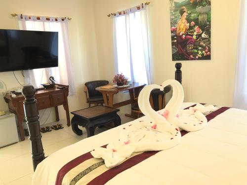 two swans are sitting on top of a bed at Naraya Homestay in San Pa Tong