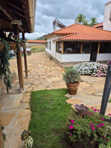 a courtyard with a house and some flowers at Pedacinho do céu in Tiradentes