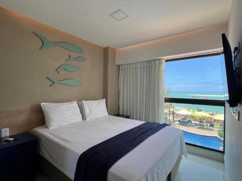 Un dormitorio con una cama y una ventana con vistas. en Plage du Porto, en Porto de Galinhas