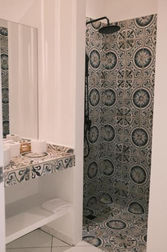 a bathroom with a black and white patterned shower curtain at El Mosquito Boutique Hotel Playa Bonita in Las Terrenas