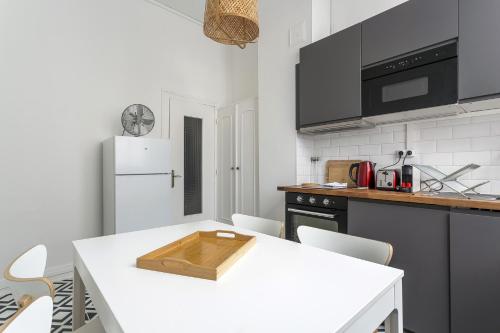Il comprend une cuisine équipée d'une table blanche et d'un réfrigérateur blanc. dans l'établissement SmartStay Bon Pasteur- Croix rousse, à Lyon