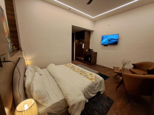a bedroom with a bed and a tv on the wall at Royal Willow Bir Billing in Chauntrā