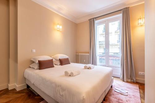 une chambre avec un lit avec deux serviettes dessus dans l'établissement Sweett - Batignolles, à Paris
