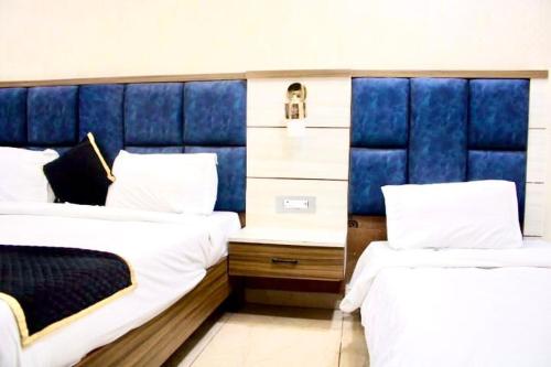 two beds in a room with blue headboards at BLACKWOOD -140 Metres- Near Golden Temple in Amritsar