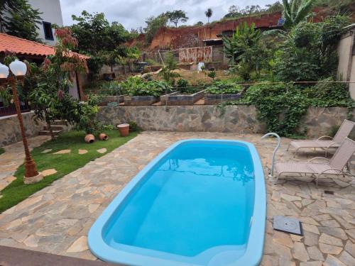 a swimming pool in a yard with a patio at Pedacinho do céu in Tiradentes