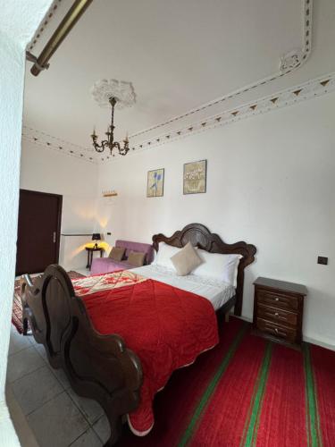 a bedroom with a large bed with a red blanket at Riad Palais D'Or in Rabat