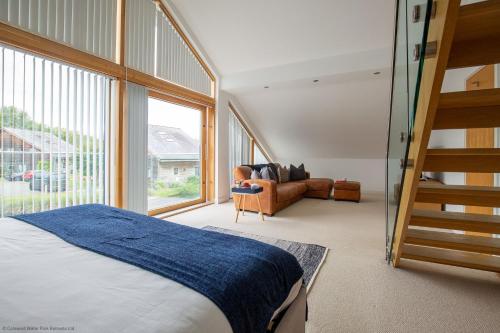 ein Schlafzimmer mit einer Treppe und einem Bett und einem Stuhl in der Unterkunft Ardross Lodge in South Cerney