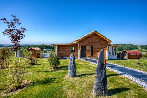 a house in the countryside with rocks in front of it at Plaisir d'Eymet du Domaine des Hauts de Rouquette in Eymet