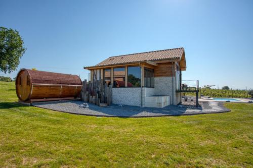a small house with a barrel in a field at Plaisir d'Eymet du Domaine des Hauts de Rouquette in Eymet