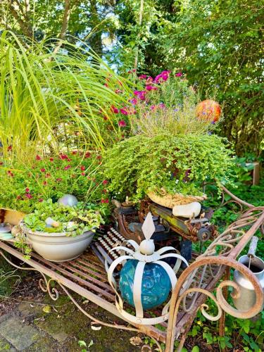 a garden with plants and a bench with flowers at NEU! FeWo Annelieses Kemenate in Finsterwalde