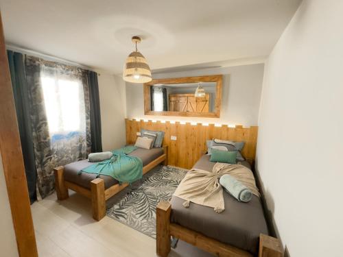 カレタ・デ・ファマラにあるBungalow Ahul Famara con pequeña piscinaのベッド2台と鏡のある寝室