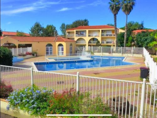 a house with a swimming pool in a yard at L'échappée verte - T2 - Confort -Piscine - Tennis- Parking - Climatisation - SudSéjourConciergerie in Canet-en-Roussillon