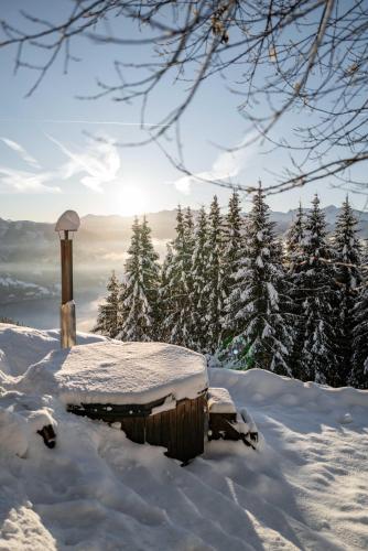 a snow covered cabin on top of a snow covered mountain at Berghotel Blaickner's Sonnalm in Zell am See