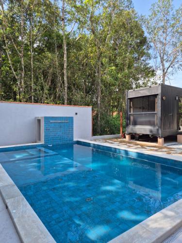 an outdoor swimming pool with a grill next to aurity at Aldeia Mar in Bertioga