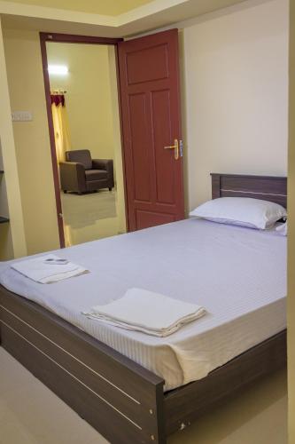 a bedroom with a large bed with a mirror at Ganesh Home Stays in Tirunelveli