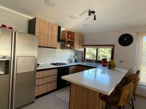 a kitchen with a stainless steel refrigerator and a counter at Casa en la Nueva Puntilla in Villarrica