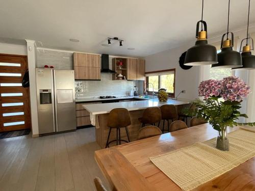 a kitchen with a wooden table and a dining room at Casa en la Nueva Puntilla in Villarrica