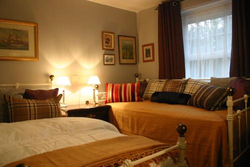 a bedroom with two beds and a window at Horse & Groom B&B in Westbury