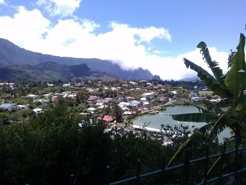 a view of a town with a lake and mountains at Au Coeur du Paradis in Cilaos