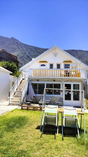a house with two chairs and a table in the yard at Au Coeur du Paradis in Cilaos