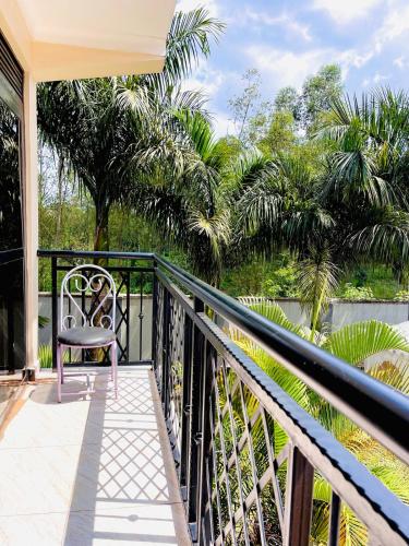a balcony with a chair and a view of the water at Rafah Apartment in Namugongo