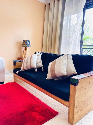 a blue couch in a living room with a red rug at Rafah Apartment in Namugongo