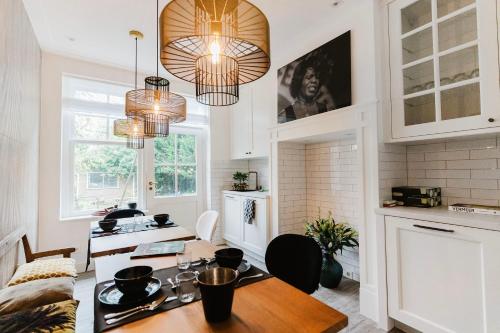 a kitchen with a table and two chandeliers at Villa335 boutique b&b in Amsterdam