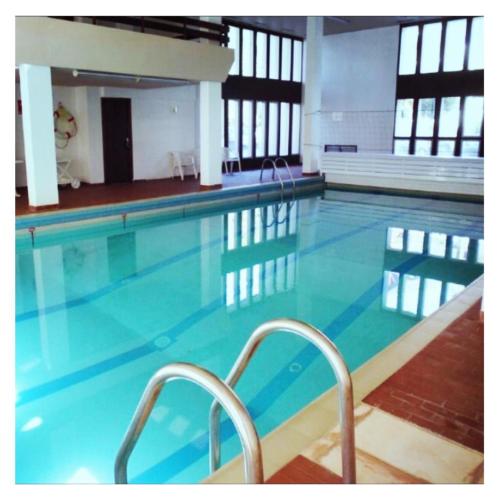 une grande piscine avec un escalier. dans l'établissement Appartement 58 m2 avec PISCINE INTÉRIEURE Vue Montagne Centre Village , Parking Privé, à Saint-Lary-Soulan