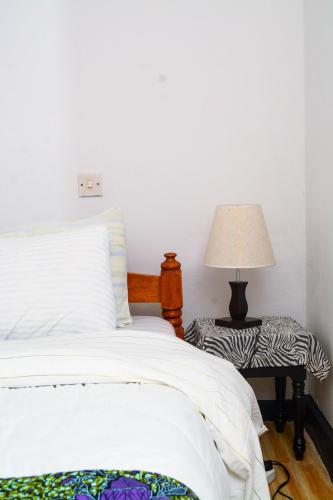 a bedroom with a bed and a table with a lamp at Ethiopian restaurant and lodge in Arusha